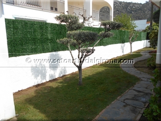 Muntatge sobre mur d'una tanca de malla simple torsió i seto artificial girona